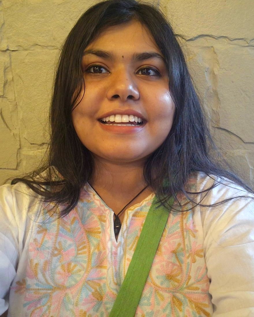 Vishakha smiling, wearing a white embroidered kurta