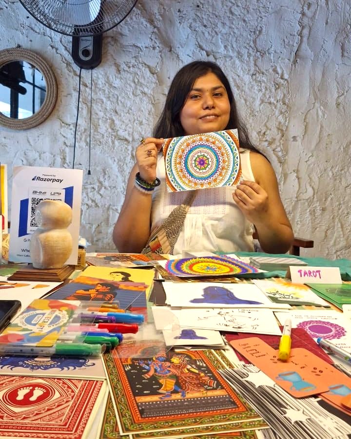 Vishakha at her Art Pop-Up stall holding a hand-coloured mandala