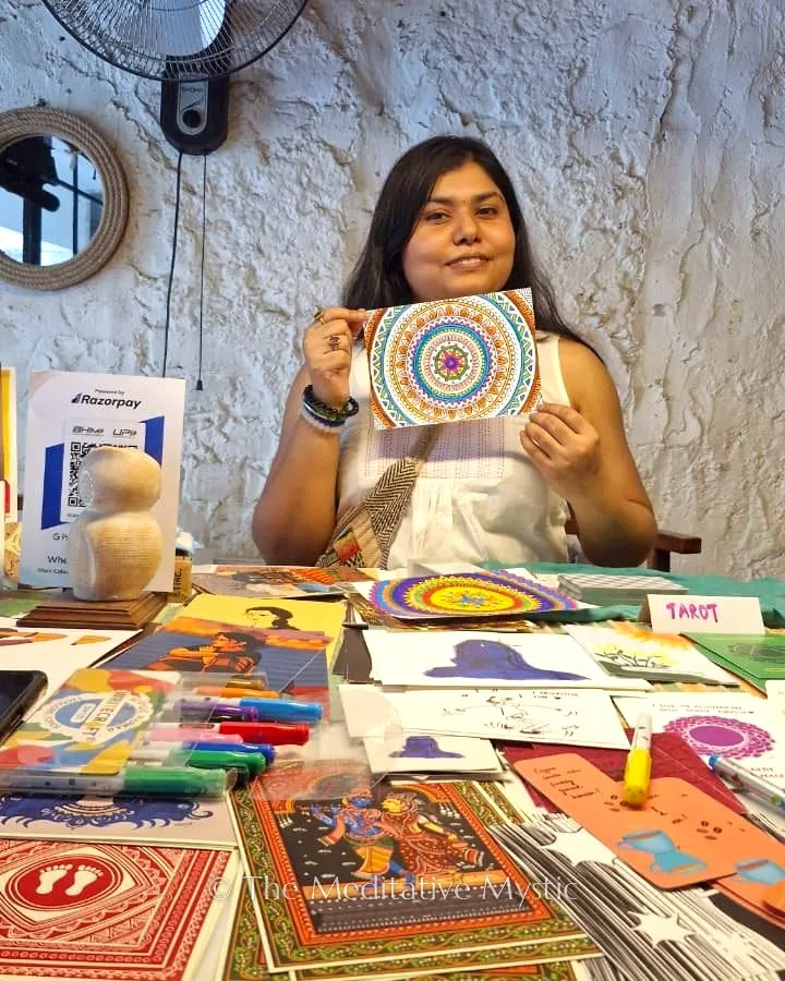 Vishakha at her Art Pop-Up stall holding a hand-coloured mandala