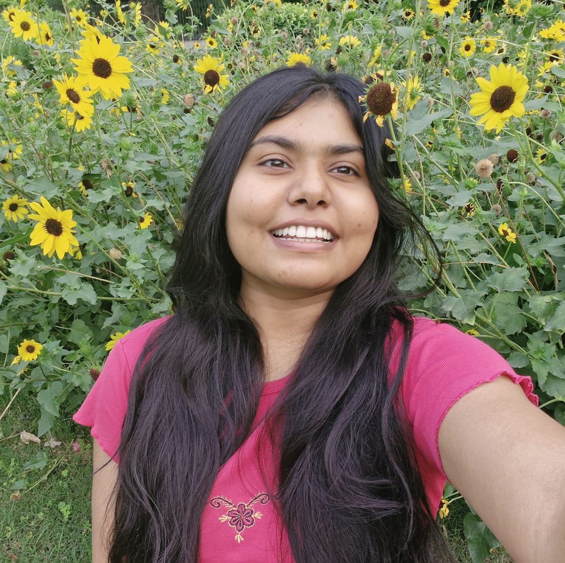 Vishakha Gautam smiling in front of sunflowers