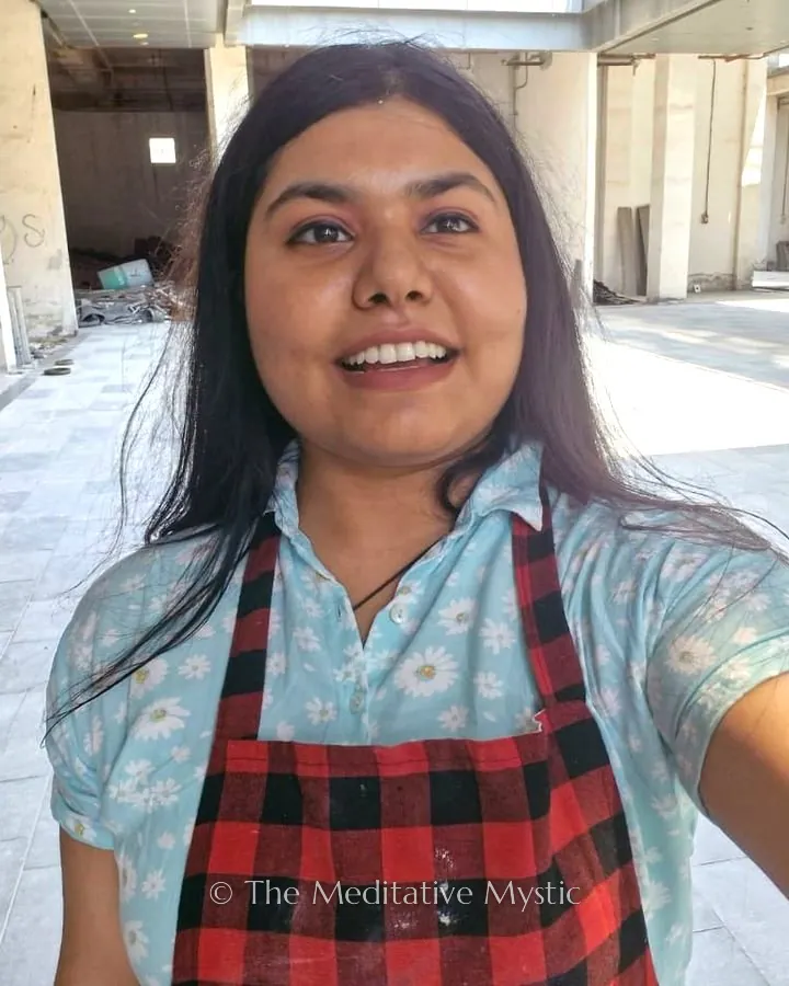 Vishakha in her painting apron, smiling